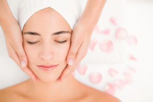High angle view of an attractive young woman receiving facial massage at spa center